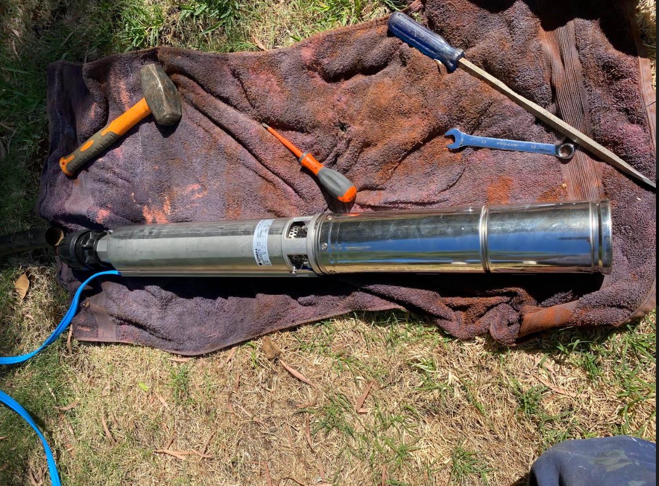 Submersible bore pump pulled and laid out with tools during a bore investigation in Perth