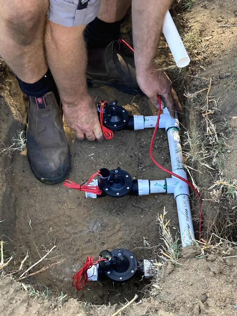 Technician repairing a reticulation solenoid valve in a Perth garden