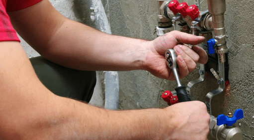 man holding wrench doing reticulation repairs in Perth