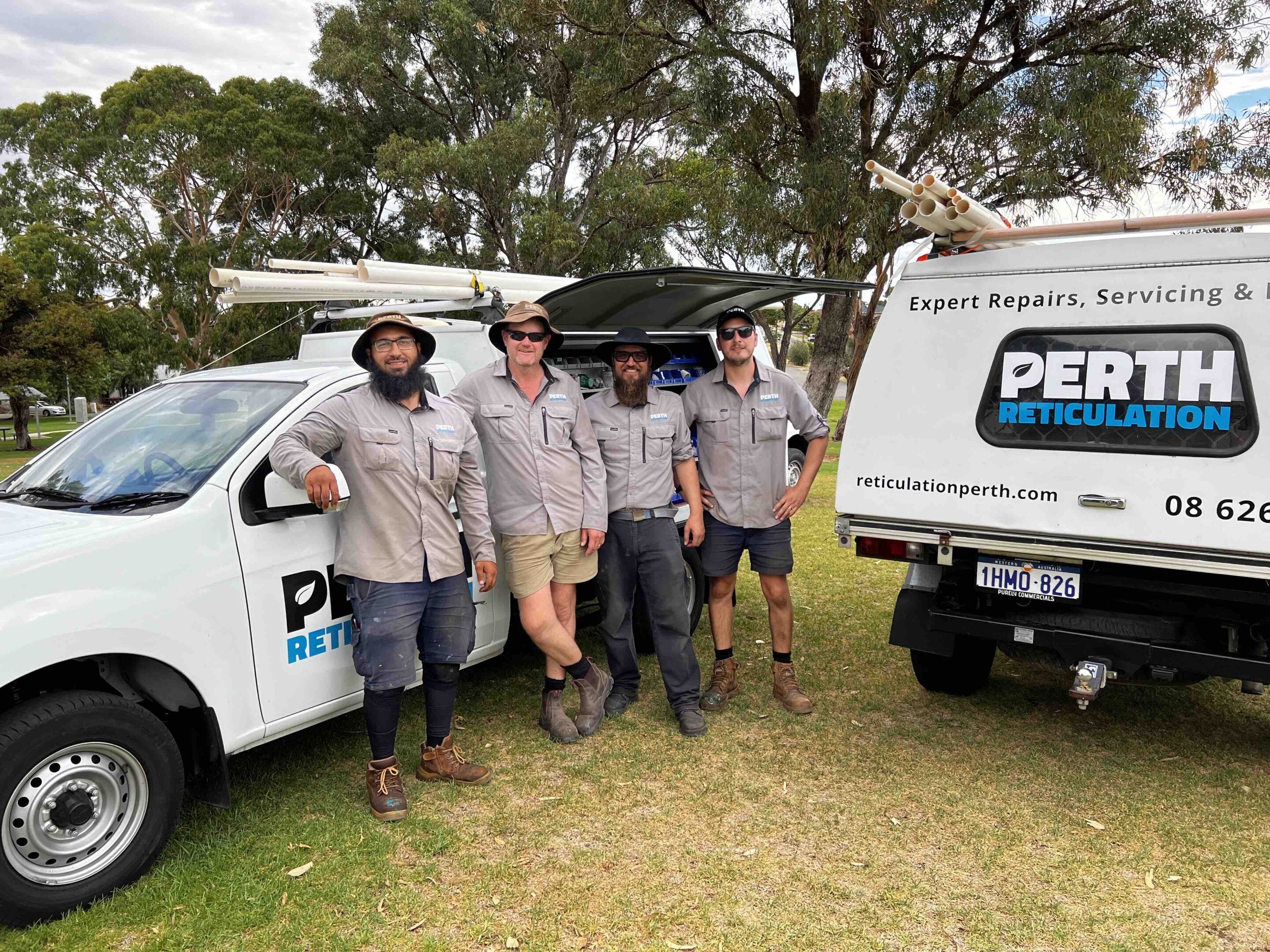 Team of reticulation technicians by work utes