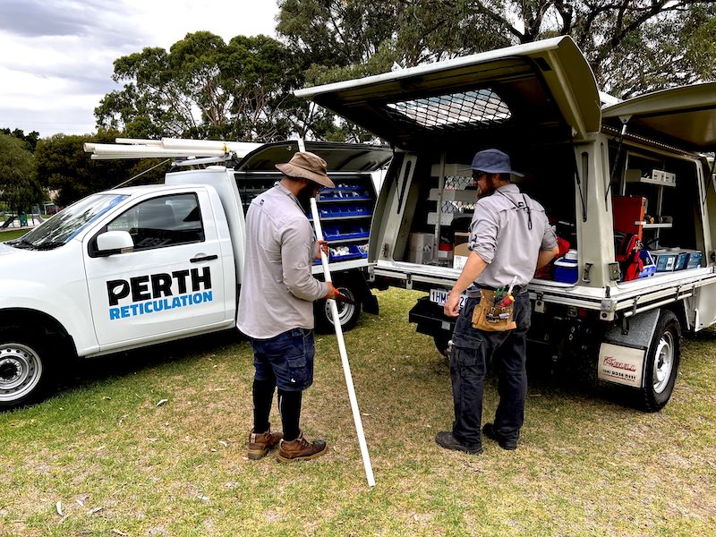 Reticulation technicians and service vehicles fixing pipe